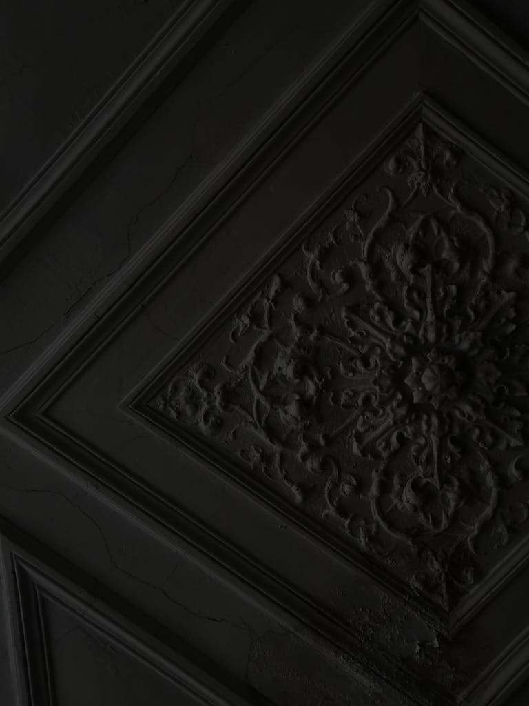 From below of ceiling with ornamental square molding and geometric lines in dark building