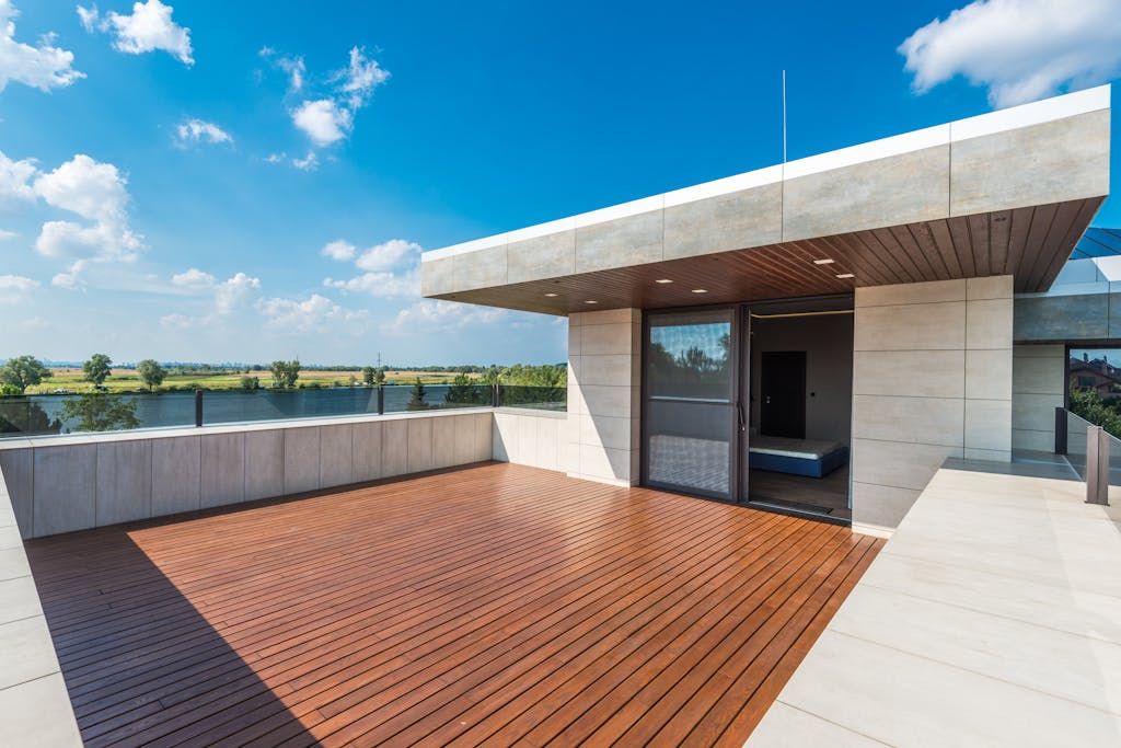 Spacious rooftop terrace offering a stunning view of the river and countryside under a bright blue sky.