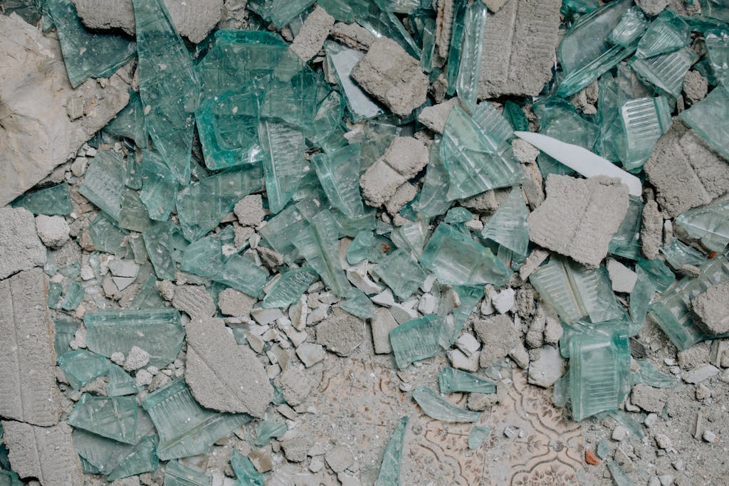 Detailed close-up of shattered glass fragments and concrete rubble showcasing texture.